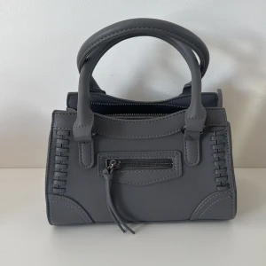 Väska - Grå trendig och rymlig väska från Gina, längre band finns