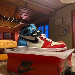 Nike Air Jordans i rött, blått och vitt - Säljer ett par Jordan 1 fearless i storlek 45. Sparsamt använda men crease finns dock. Säljer pga att de vara står å samlar damm.  Box kan följa med vid överenskommelse och diverse skosnören 