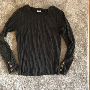 Tröja - Mörkgrå ribbad långärmad tröja från Zara. Knappar vid ärmarna. Stretchig så passar större storlekar. Pris kan diskuteras 