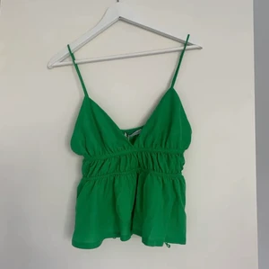 Grön Zara topp! - Säljer denna fina gröna topp från Zara endast testad så i toppenskick med prislapp kvar! Storlek S. Köparen står för frakt och bud är bindande. Där jag köpte den var denna den sista i storlek s💚 Köp direkt för 350kr💚Lånade bilder från Ida Åberg