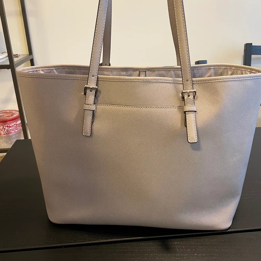 Säljer min nästan oanvända MK shoppingbag. Den har för det mesta stått i ett skåp för att det är inte riktigt min stil. Väskan är äkta, finns QR kod inuti som man nog kan gå till en butik och få bekräftat. Färgen är ljusgrå och storleken är large. . Väskor.