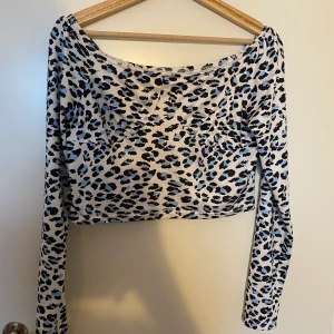 Blå leopard topp  - En fin ljusblå Leonard topp med kupor och spets runt halsen. 