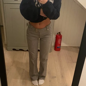 lågmidjade kostymbyxor - Grå lågmidjade kostymbyxor köpta secondhand. Strl 38. Går ner till marken på mig som är 167. Köpare står för frakt!