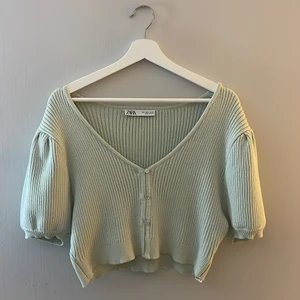 Zara topp strl L - En pastellgrön, stickad topp från Zara. Knapparna går inte att öppna då jag diskret har handsytt ihop dem längs framsidan (går att sprätta upp om man vill). Toppen är använd ca 2-3 gånger och legat i garderoben i väntan på användning. Skriv för fler bilder i dagsljus! Inga defekter, precis som ny. Nypris 399:- mitt pris 120:- (+62kr frakt). Ingen retur💚
