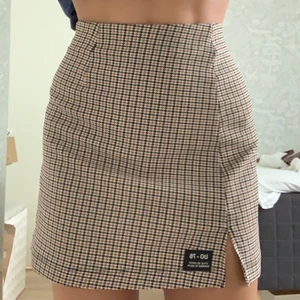 Rutig kjol från Urban Outfitters - Superfin rutig minikjol i neutrala färger. Knappt använd pga fel storlek! Passar perfekt till våren!