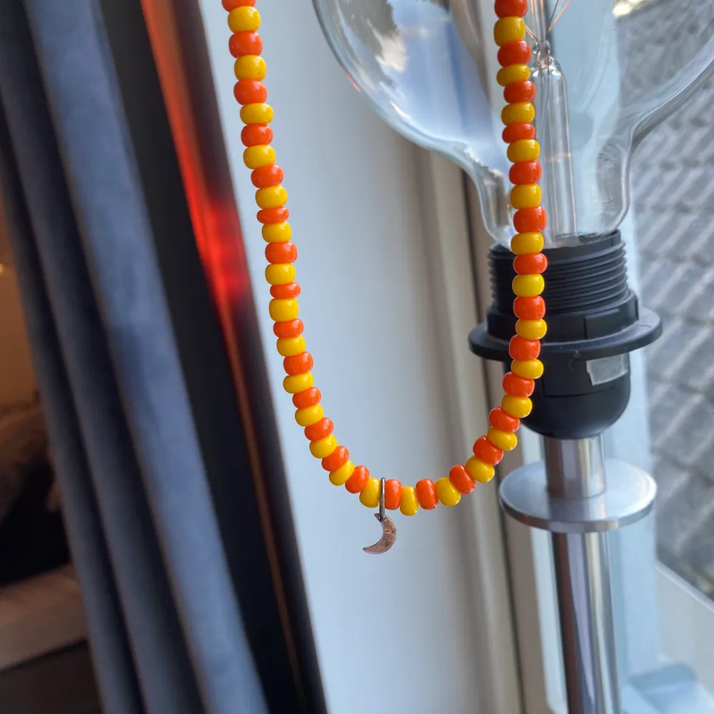 Säljer detta egengjorda pärlhalsband i färgerna orange och gul med en silvrig halvmåne på!💛🧡. Accessoarer.