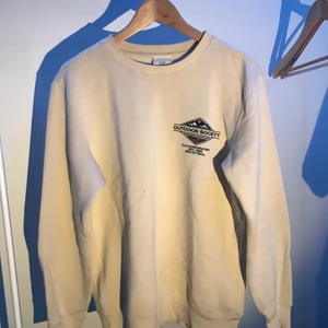 Collegetröja - Beige/vit collegetröja från H&M/Outdoor Society i storlek small. Broderad logga på vänster bröst.