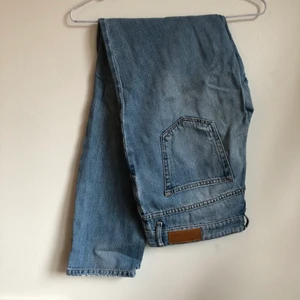 Jeans - Slitna blå momjeans med hål över båda knän. Rätt långa så går att rulla upp dem. Regular waist. 