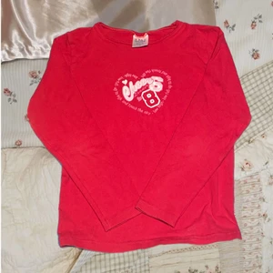 Röd tröja med tryck - snygg röd tröja med tryck, bra skick förutom lite nopprig och liten del av trycket är sprucket, men tycker det ger tröjan sin charm. rensar garderoben så säljer vidare. Barnstorlek (130) men skulle säga passar XXS/XS. Är stretchig men kan töjas ut mer (står på lapp) Köparen står för frakt. ❤️