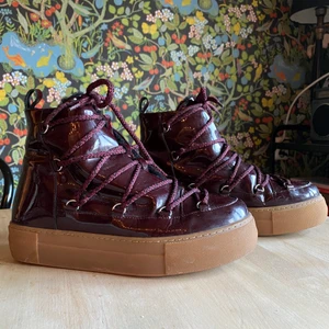 Vinterskor - Jättesnygga vinröda vinterkängor från &OtherStories! De är i storlek 39, är fodrade och i ett glansigt material. I väldigt fint skick, förutom en liten skada på en av skornas innersida (se bild två) syns inte när man har skorna på, men det skulle även gå att fixa med lite lim! Nypris ca 1400kr🥰