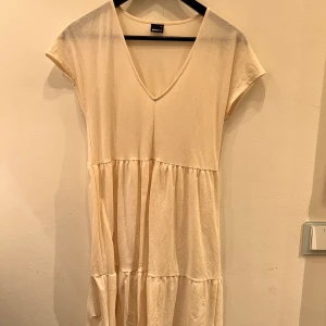 Vit klänning - Vit klänning i svalt tyg. Köpt på Ginatricot, använd ca 2 ggr. Inga fläckar eller andra defekter. XS men passar även S. Går till knäna ungefär.