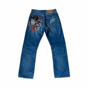 Vintage Ed Hardy baggy jeans - Ett par as feta vintage baggy jeans från märket Ed Hardy. Lot 2009. I fint skick. Fett sköna och ger dig värsta drippen. Rhinestones på ”geisha girl” motivet bak! Deadstock very rare to find. Säljer då de tyvärr är för stora för mig :(