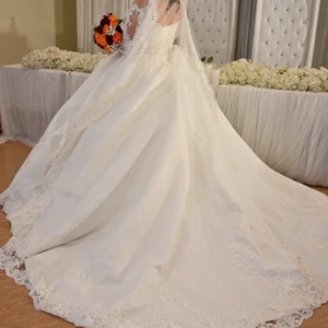 Bröllopsklänning multisize 38-42 - Den köptes för ungefär ett år sen för 17000kr och använder bara några timmar den tredje september 2021. Kjolen mäter till ungefär 1 meter på golvet bakom dig och har metall som håller kjolen i plats och form. Kjolen är en aning ”smutsig” av att den dras på golvet bakom än förutom det är den i perfekt skick och kemtvätt ordnas efter överenskommelse.