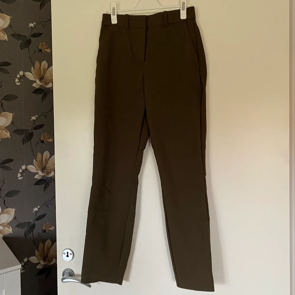 Kostymbyxa/slacks i brun färg med lite grön nyans i, storlek 34. Använd fåtal gånger så jättebra skick!. Jeans & Byxor.