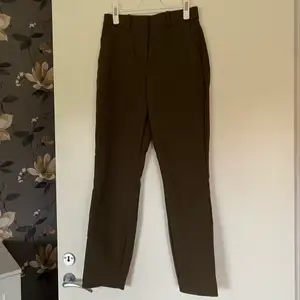 Kostymbyxa/slacks i brun färg med lite grön nyans i, storlek 34. Använd fåtal gånger så jättebra skick!