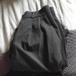 Kostymbyxor från Cubus st 34, högmidjad modell - Säljer ett par svarta kostymbyxor från Cubus i storlke 34, då de är stora i storlek var de tyvärr förstora på mig. Aldrig använda, endast provade och har legat i garderoben. Höga i midjan, fickor fram men inte bak. Lite boxigare modell