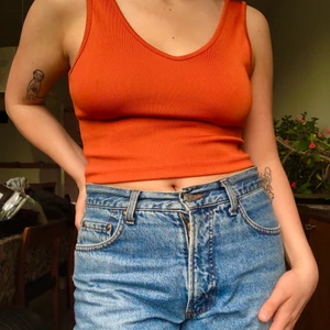 V-ringat linne - Charmigt och bekvämt linne i en klarorange och lite glansig färg. Ganska tjockt och stretchigt tyg. 