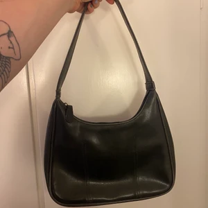 Väska - En trendig, svart skinnväska som är inköpt på secondhand! Kommer tyvärr inte i användning för mig! 