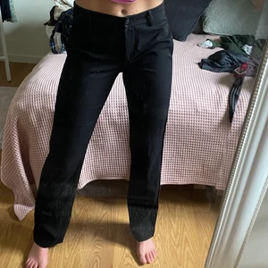 Svarta kostymbyxor  - Svarta stilrena kostymbyxor med rosa rand på sidan. Bra skick. Storlek 36. Pris: 120kr. 