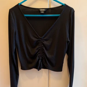 Svart croppad topp - V-ringad midjetopp från Monki. Använd en del men i fint skick! 