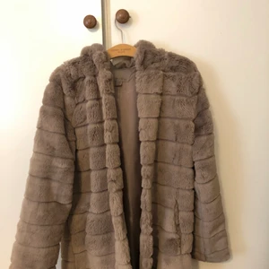 Fake pälsjacka strlk 38 - Säljer nu min pälsjacka i färgen brun/beige som endast är använd 2-3 gånger, jag skulle räkna den som nyskick förutom att det finns ett litet hål i den ena fickan men det märks inte av. Den är storlek 38 men jag skulle säga att den passar 36 också. Nypris 450 Mitt pris 300