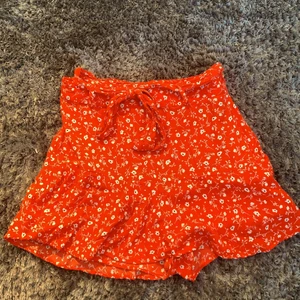 Kjol med inbyggda shorts från Zara - Röd kjol från Zara med inbyggda shorts perfekt nu till sommaren, storlek S. Säljer då den tyvärr blivit för liten för mig. En liten reva på framsidan av kjolen som jag har sytt ihop. Skulle säga att den är mer röd i verkligheten.