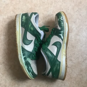 Nike sb dunks - Vita nike sb dunks målade till grönt med skofärg, halvgula sulor på sidan bruna på botten, ej original skosnöre, färgen har slitits och dem har skejtats lite som visat på tredje bilden. Perfekta skor att skejta med eller använda normalt. Storlek eu 43