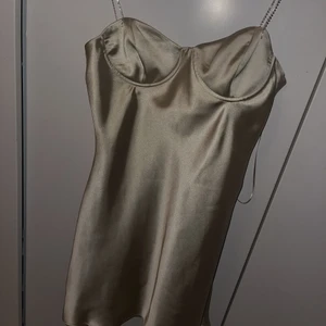 Zara nyårs klänning i satin - En super populär klänning från zara som är beige/grön färg i satin. Aldrig använd och lappen är kvar. Budet är just nu på 400kr