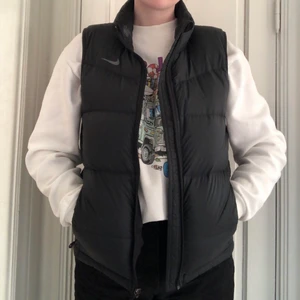 NIKE VÄST - Svart väst från Nike i strl M. Köpt begagnad på Sellpy på herravdelningen, men tycker själv att storleken är mer som en M i dam. Aldrig använd själv pga för liten. Inga defekter, fint begagnat skick. Polyester & dun. Tre innerfickor.