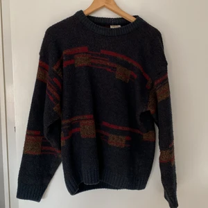 Stickad tröja - Stickad tröja från Italien i storlek M. Tröjan är navy med röda och bruna mönster