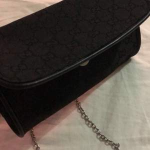 Fin svart Gucci handväska med lång kedja som du kan ta av om du vill. Två slitningar vid kanterna inuti vilket du kan se på sista bilden, syns knappt. Endast ett hyfsat stort fack. 