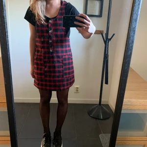Rutig klänning - En söt röd/svart rutig klänning som är perfekt för hösten/vintern. Knappt använd och är i bra skick. Frakt ingår inte i priset.