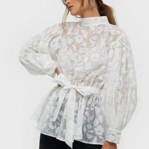 Blus med rosett i midjan - NLY Trend - Blus i organza med ballongärmar och resår i midjan, använd en gång. Köpt för 499kr. Köparen betalar frakten 💌