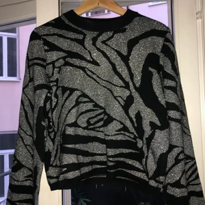 Stickad tröja med coolt mönster. - Glittrig stickad tröja i coolt mönster, vida ärman med randiga muddar. 