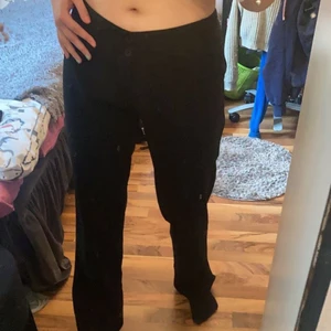 Randiga kostymbyxor  - Säljer dessa fina svart-randiga kostymbyxor. Dom är lågmidjade och stängs med 2 knappar och dragkedja. Man ser lite dåligt på första bilden. Men på andra bilden ser man att dom är randiga. OBS! Dessa byxor är förstora för mig. Jag har satt ett hårband i svanken så att man kan se lite bättre hur dom ser ut, om dom skulle passa. (Jag har vanligtvis M/38. Har lite större lår så dom passar vid låren. Men dom är alldeles förstora i midjan)