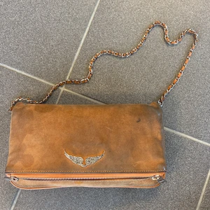 Zadig och voltaire väska  - Jag säljer nu min älskade Zadig & voltaire väska, den är väll andvänd men ändå i bra skick. Den är i mocka färg mot orange. 