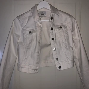 Vit jeansjacka ifrån NA-KD - Säljer denna fina vita jeansjacka, som är kortare i modellen. Tyvärr har den dock aldrig kommit till användning då den är en aning för liten för mig. Jackan är i storlek 32🥰