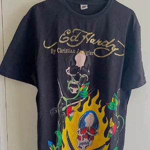snygg y2k ed hardy tshirt - säljer min snygga tshirt som e trendigg!!! y2k ed hardy som sitter som M-L <3 alla rhinestones kvar 💕 skriv gärna för att köpa den direkt eller för att buda! Budgivning ska stängas när jag får ett rimligt pris. BUD LIGGER PÅ: 300kr