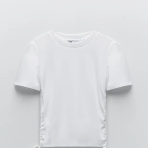 Zara t-shirt - Säljer denna vita tröja från zara med knytningar och snören på sidorna! Väldigt fin och passar till allt! Den är inte ribbad utan vanligt t-shirt material. Endast använd några få gånger och är som ny❤️