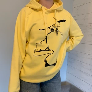 Hoodie med tryck  - Ljusgul hoodie med svart tryck som föreställer en kvinna med hatt. Köpt från Sisters point i Köpenhamn, använd fåtal gånger och är i nyskick. 