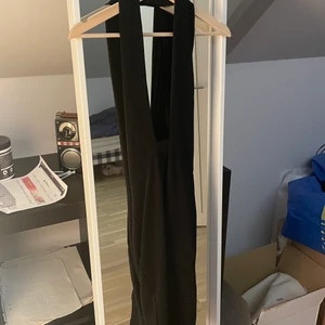 Svart glittrig klänning  - En svart/glittrig (midi) klänning från bikbok i storlek M. Aldrig använd och helt ny. Knyts runt nacken och går att använda vanligt och korsad över bröstet. Kan mötas upp i Malmö/ Lund området annars står köparen för frakten. 