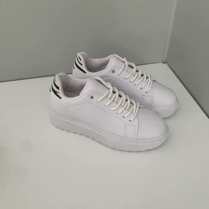 Vita Sneakers - Helt nya sneakers från Nelly, har inte kommit till användning då dem är för små. Vita, med zebramönster i bak. Storlek 37. Nypris 349 men säljer för 199kr  