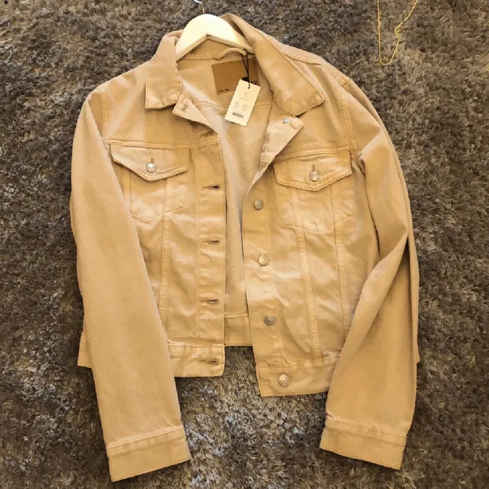 Oanvänd beige jeans jacka. Passar perfekt nu till våren. Prislappen sitter kvar på jackan. Köpt i Lager 157 för 399kr. Säljer då den inte kommer till användning. Silvriga detaljer. Fickor på framsidan. Storlek L fast passar mig som har s-M på jackor beroende på hur du vill att den ska sitta. 🌻. Jackor.