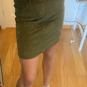 Grön manchester kjol - En charmig grön manchester kjol i stretchigt material med en liten slits på baksidan. Använd en gång så den är så gott som ny. Kjolen är i S men kan mycket väl passa en M också. Köpt på Cubus för ca 250kr. Frakten ingår i priset:) (Det är spegeln som är smutsig och inte kjolen)