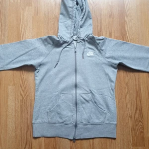 Nike grå hoodie  - Koftan är välanvänd och har 3 supersmå hål på armarna som jag har sytt ihop (ett syns på bild 3). Annars är den verkligen bekväm och snygg. Grå Nike hoodie i st S. Skriv vid intresse : ) Frakt tillkommer! 