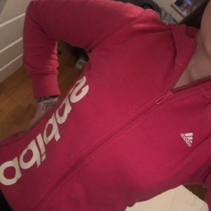 Rosa Adidas hoodie, strl xs-s - • Oanvänd rosa super mjuk & skön hoodie från adidas • tröjan har varken skador eller smuts, det är min kamera som är dålig (bild 3) • strl 13 - 14 år (160cm) men jag skulle säga att den passar utmärkt på xs-s också! • 60kr + frakt #oanvänd #adidas #hoodie #rosa