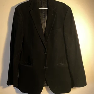 En svart Manchester kavaj av märket SIR - en svart Manchester kavaj som är figursydd. Kavajen är i märket sir och har två fickor fram och två större inne fickor och två mindre. 