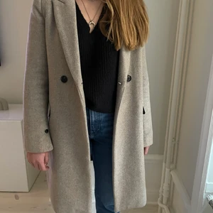 Kappa strl M - Beige kappa från Mango i 50 % ull. Ca. 3 år gammal men inte så flitigt använd. Inget nopprig i tyget eller sliten. Nypris 800 kr.