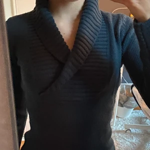 Snygg stikad tröja  - En jätte snygg V-ringad stickad tröja. Framhäver verkligen ens former speciellt bysten. Den är blå grön tonad och helt oanvänd. 