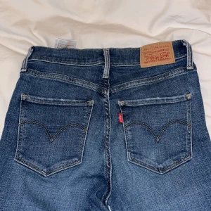 Blåa Levis, medel midja strl 26 - Blåa Levis jeans i storlek 26. Mycket sköna, inget slitage på de. Modell 312 ”shaping slim” 💖